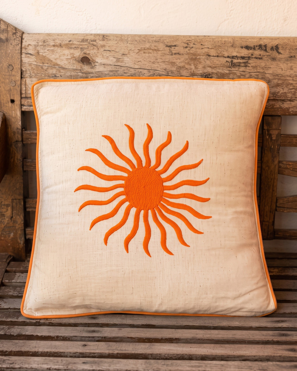 Soleil Cushion Orange on a wooden bench in Ibiza — La Fleury