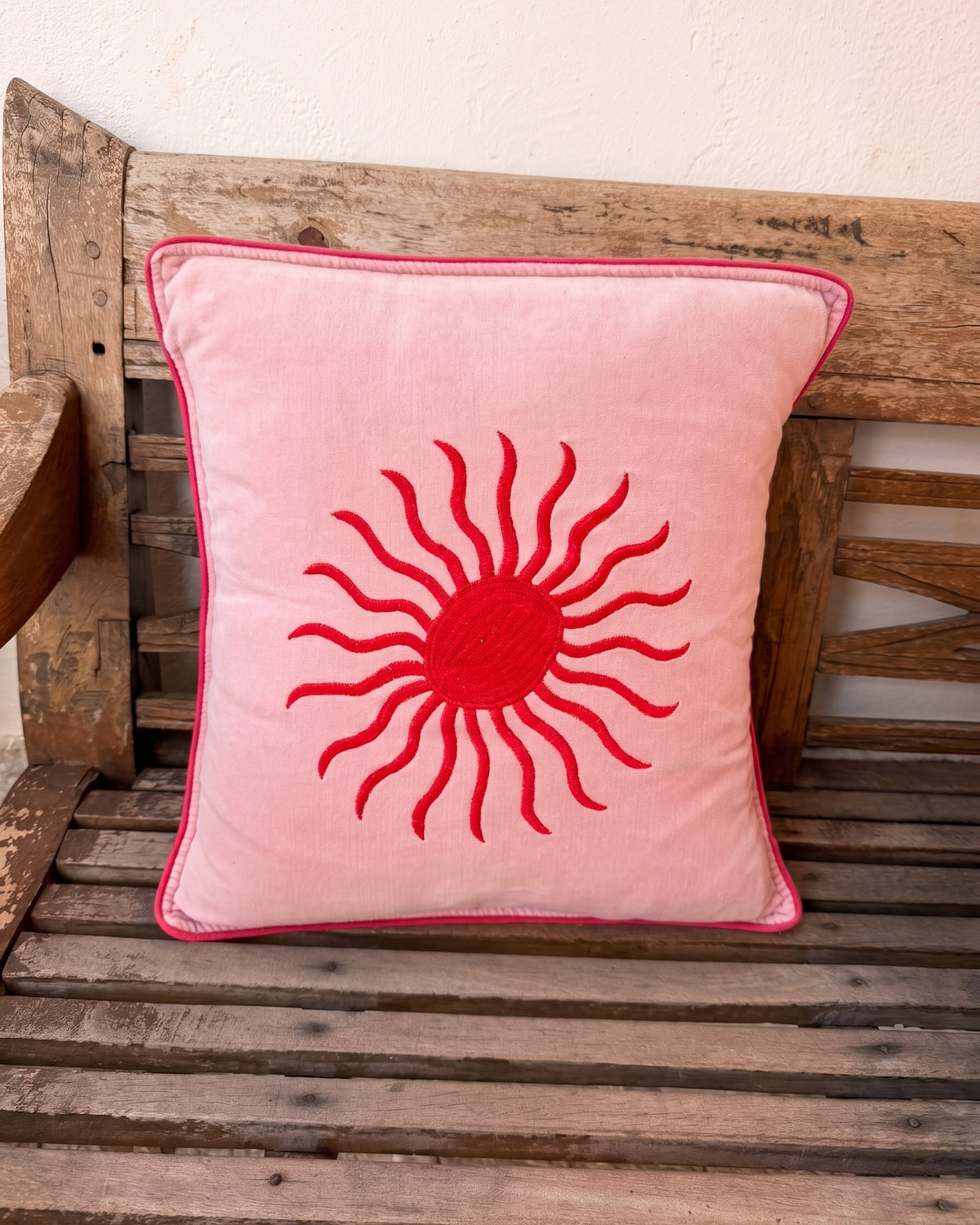 Soleil Cushion Pink and Red on a wooden bench in Ibiza — La Fleury
